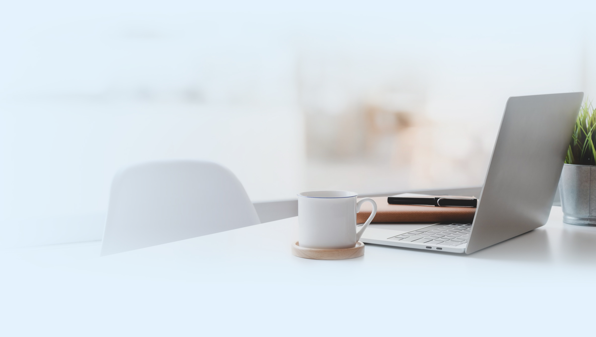 Coffee cup and laptop on a desk in a smart office setting